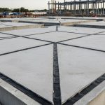 Chantier avec dalles en béton et joints de dilatation pour prévenir les fissures.